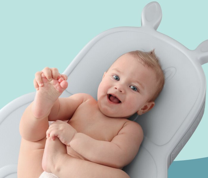 Smiling baby lying on a Babypal changing pad